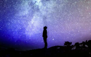 SMG ROI imagery — silhouette of person looking up at starry sky